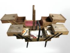 Two teak concertina sewing boxes, one containing sewing items.