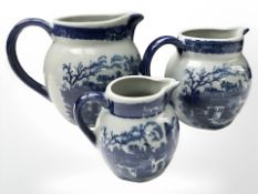 A set of three graduated reproduction Staffordshire blue and white jugs, tallest 19 cm.