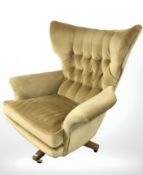 A 20th century G Plan model 6250 Blofeld swivel lounge armchair in buttoned mustard upholstery,