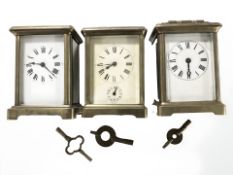 Three brass carriage timepieces with platform escapements, tallest 14 cm including handle.