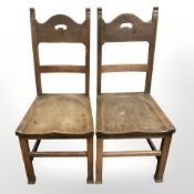 A pair of Arts and Crafts oak chairs with recessed seats.