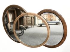 An Edwardian mahogany oval mirror and two further oak mirrors, largest 65 cm wide.