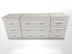 A contemporary white three drawer chest with plate glass top,