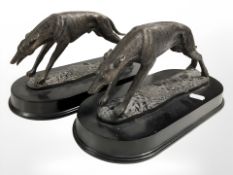A pair of bronzed resin figures of sprinting greyhounds on plinths, length 31 cm.