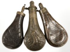 Three 19th century metal powder flasks, including an embossed copper example depicting dead game,