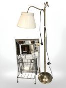 A contemporary mirror, a metal shoe stand and a brass standard lamp.