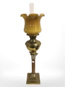 A brass Corinthian column oil lamp, with butterscotch glass shade and clear chimney, height 74 cm.