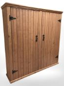 A stained pine two door cupboard, 172 cm x 38 cm x 171 cm.