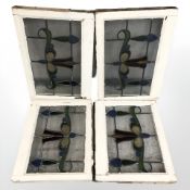 Three early 20th century stained and leaded glass windows in painted surrounds,