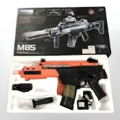 An M85 electric powered 6 mm BB airsoft gun, in box.