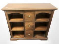 A reproduction hardwood bookcase, fitted central drawers, 101 cm x 35 cm x 90 cm.