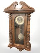 An early 20th century walnut eight day wall clock, with pendulum, height 85 cm.