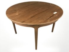 A 20th century circular teak table with internal leaf,
