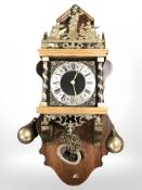 A reproduction continental wall clock with brass pear weights, length 62 cm.