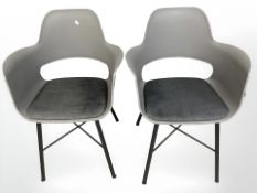 A pair of molded plastic chairs on metal legs.