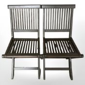 A pair of stained teak folding garden chairs