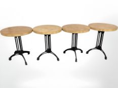 Four circular pine topped tables on painted metal supports,
