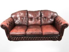 A Chesterfield style oxblood buttoned leather three piece lounge suite,