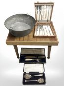 An occasional table, a galvanised bowl and boxed cutlery.