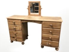A contemporary pine dressing table, 132 cm x 38 cm x 73 cm, and a mirror.