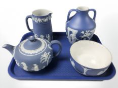 A Wedgwood blue and white Jasperware twin handled urn, jug, teapot and bowl.