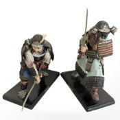A pair of papier mache and cloth figures of samurai warriors on ebonised plinths, tallest 33 cm.