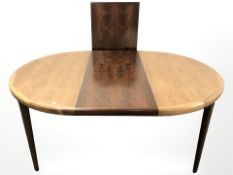 A Danish oval extending dining table with two leaves,