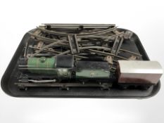 A vintage tin plate locomotive, two further train cars and a quantity of track.