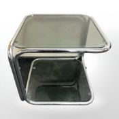 A chrome and smoked glass two tier table on castors, width 55 cm.