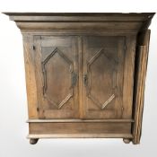 A 19th century Continental paneled oak double door cabinet on bun feet,