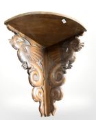 A carved walnut corner shelf decorated with dragons, length 65 cm.