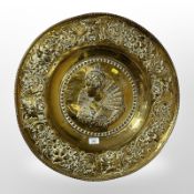 A continental embossed brass charger, diameter 57 cm.