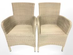 A pair of wicker armchairs.