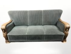 A continental carved oak three piece lounge suite in striped upholstery, settee 186 cm long.