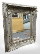 A Rococo style bevelled mirror in a silvered frame, 91 cm x 106 cm.