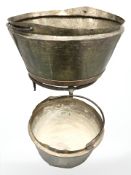 Two swing handled cooking pots, one on wrought iron stand,