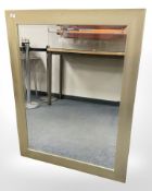 A contemporary bevelled mirror in a gold effect frame, 94 cm x 120 cm.