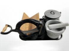 A granite pestle and mortar, a cast iron cauldron with lid and a Danish bread slicer.
