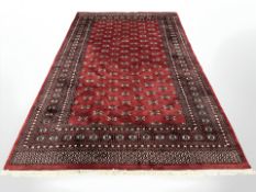 A Lahore Bokhara carpet, Pakistan, the claret field with repeat gul motif,