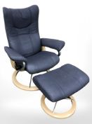 A contemporary Scandinavian swivel lounge armchair and matching footstool in blue fabric.