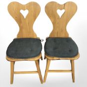A pair of 20th century pine occasional chairs with heart shaped back rests