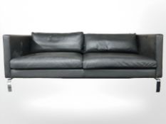 A contemporary Scandinavian black leather three seater settee on chrome legs,