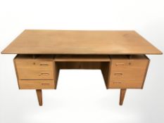 A 20th century Danish teak twin pedestal writing desk, fitted with six drawers,