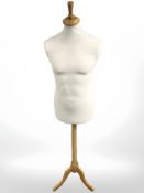 A mannequin torso on tripod stand.