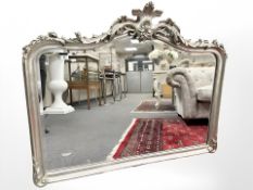 A Rococo style bevelled overmantel mirror in a silvered frame, 124 cm x 100 cm.