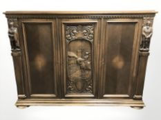A 20th century continental heavily carved oak triple door sideboard, 176 cm x 50 cm x 132 cm.