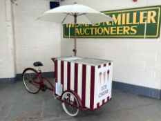 An ice cream vendor's traditional style tricycle with freezer and parasol