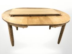 A Danish blonde oak extending dining table, with three leaves,