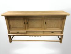 A Danish blonde oak triple door sideboard, 176 cm x 50 cm x 91 cm.