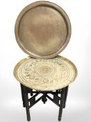 An Eastern bobbin turned brass toped table and further copper shallow dish